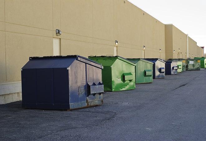 construction workers disposing of debris in large dumpsters in Amsterdam, NY